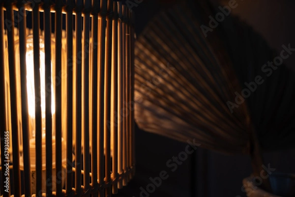 Obraz a wooden lamp shines on the table