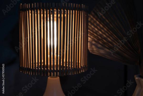 Obraz a wooden lamp shines on the table