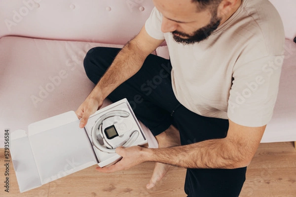 Obraz Man unbox a neck device massager