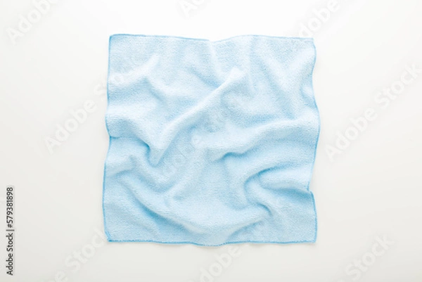 Fototapeta Light blue wrinkled dry soft microfiber rag for different surfaces wiping on white table background. Top down view. Closeup.