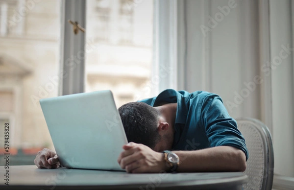 Obraz depressed man with head leaning on computer