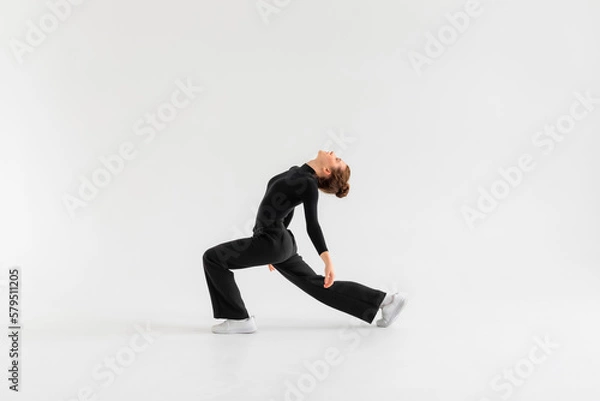 Fototapeta Young Girl, professional hip-hop dancer in a black clothes performing over a Isolated white background with a plenty of copy space.