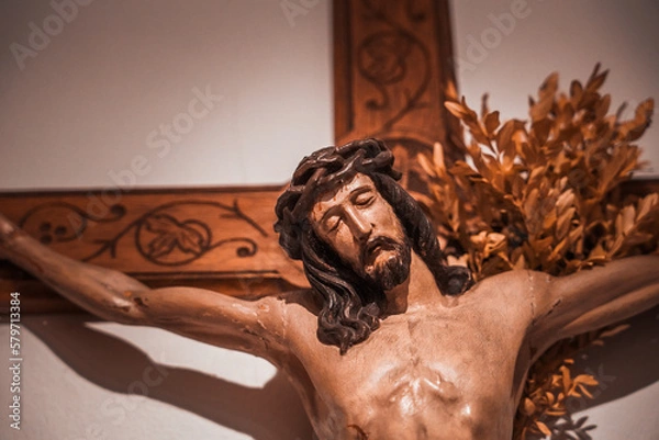 Fototapeta Jesuskreuz an einer Wand mit Buchszweigen