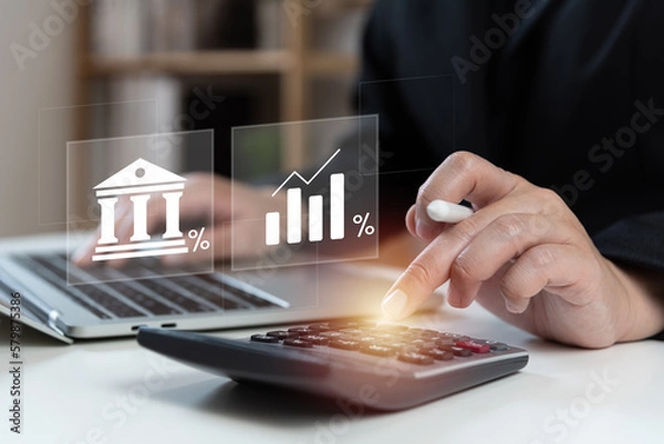 Fototapeta Businessman using calculator to calculate the bank interest rate, high interest rate, percentage, financial profit return and dividend concept, ROI, ROE, IRR.