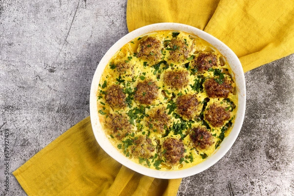Obraz Beef and rice meatballs in cheese paprika sauce in a white baking dish on a dark grey background. Top view, flat lay
