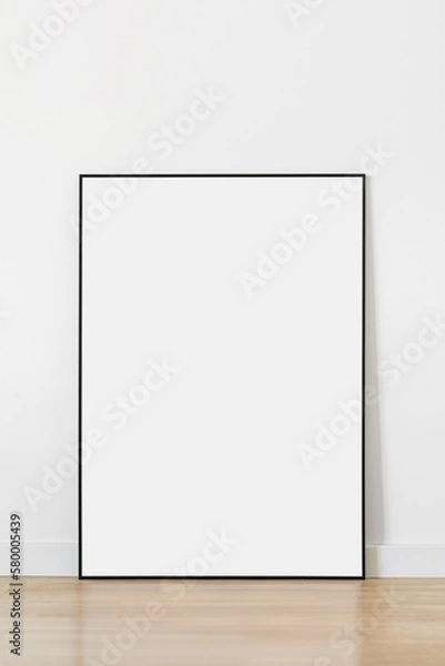Obraz Empty vertical frame mockup standing on floor in modern minimalist interior on white wall background, Template for artwork, painting, photo or poster
