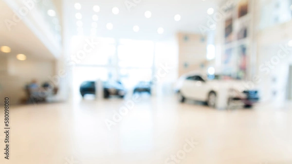 Fototapeta Blurred abstract dealership store, with defocused cars, clients and staff with  soft lightning