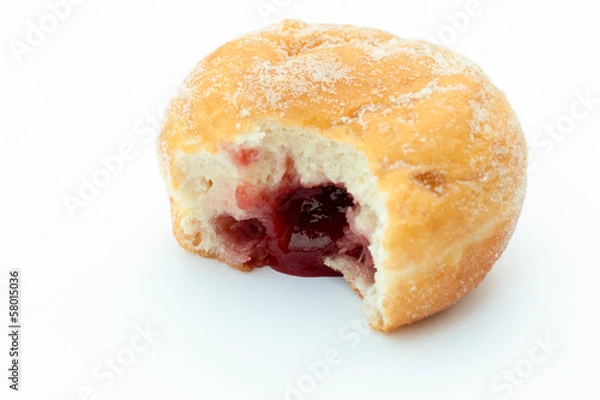 Fototapeta Jam donut with a mouthful taken out and jam showing