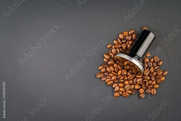 Obraz Coffee Tamper with black shiny Handle. Top view on black background with coffee beans. Barman tool for pressing down ground coffee, a tamper for a coffee machine