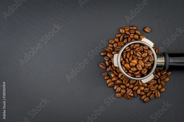 Obraz Porta filter with black shiny Handle. Top view on black background with coffee beans. Barman tool for making an espresso with the right pressure.