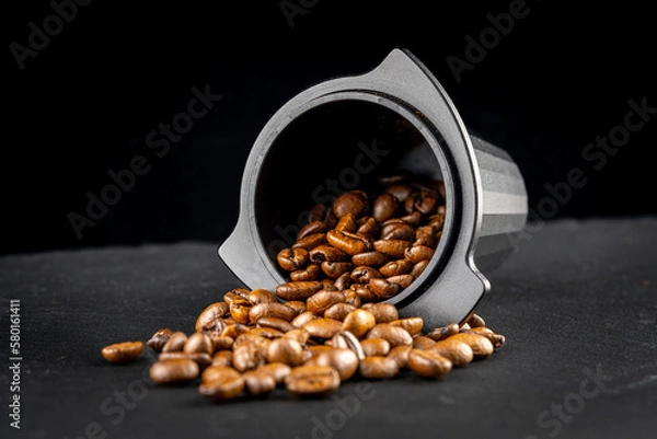 Obraz Dosing cup with black matte texture. Top view on black background with coffee beans. Barista tool for dosing coffee beans and using it to when grinding beans. Focus on the beans in the center..