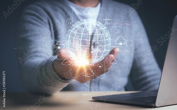 Obraz Businessman is using a laptop and hand holding virtual cloud computing with Global Internet connection,big data, internet of things, business processes, various storage systems