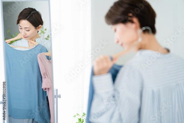 Fototapeta 鏡の前で服選びをしている若い女性　ファッションイメージ