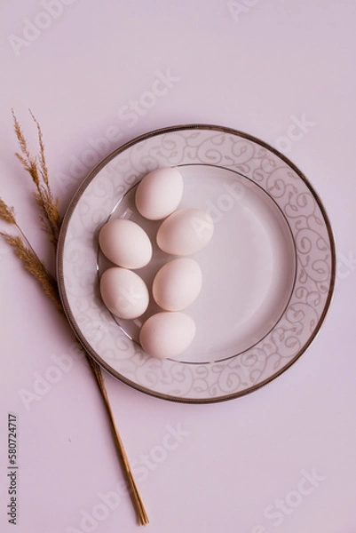 Fototapeta Chicken eggs on a plate. We are preparing for Easter. Beautiful tableware. Eggs on a white background