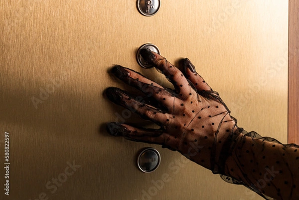 Fototapeta Close-up of a hand in a Mesh Sheer glove of an elegant girl pressing a button in an elevator. Concept of elegance and sophistication. Formal or upscale event.