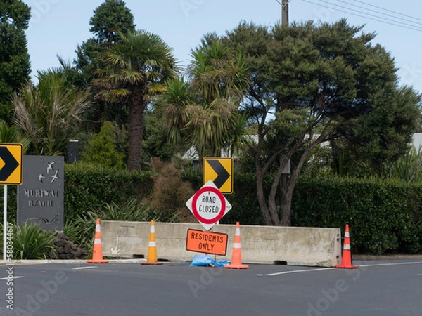 Fototapeta A road has been blocked with a concrete slab.Signs say 'road closed' and 'residents only'. Muriwai.New Zealand.Result of Cyclone Gabrielle.