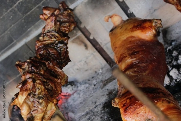 Obraz Grilled piglet and Sardinian suckling pig. Porceddu on the spit. Best red meat bbq party. Crunchy and toasted rind. Festival of roastyng and fire cooking