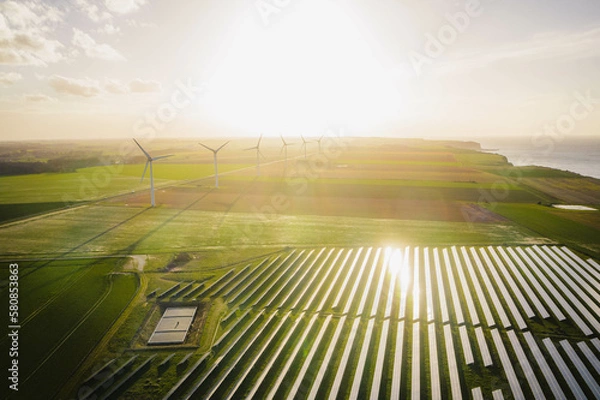 Obraz Wind turbines and solar panels farm in a field. Renewable green energy. Sunny landscape, electric energy generator for clean energy producing concept.
