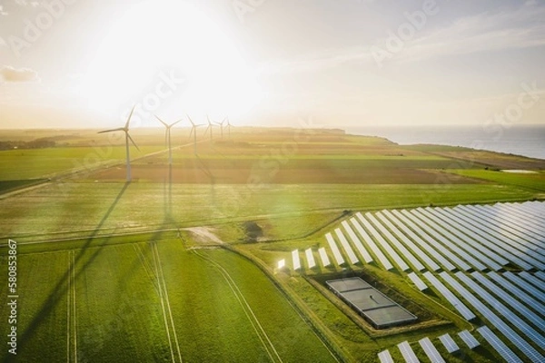 Obraz Wind turbines and solar panels farm in a field. Renewable green energy. Sunny landscape, electric energy generator for clean energy producing concept.