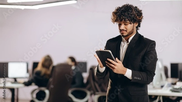 Fototapeta Handsome businessman using tablet. Indoor shot of focused office manager with digital device
