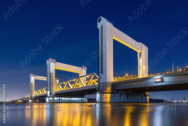 Fototapeta Botlek bridge, Rotterdam, Netherlands. View of the bridge at night.  Road for cars and railroad transport. Architectural landscape. Reflections on the surface of the water.