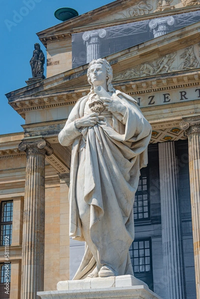Fototapeta Berlin, Germany - June 8, 2021: Statue of famous German poet and writer Friedrich Schiller at Gendarmenmarkt in Berlin near Concert Hall in historical and business downtown at blue sky