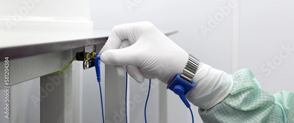 Fototapeta Bracelet on the hand of a man wearing ESD cloth and glove static resistance ESD bracelet or ground equipment, anti-static, used to safely ground is working. Semiconductor manufacturing.Banner