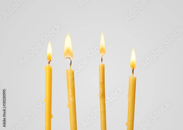 Obraz Many burning church candles on light background