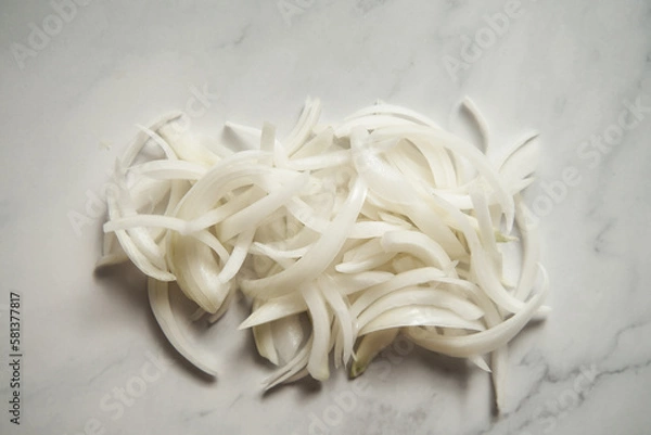 Obraz Julienne cuted onions on white marble background. Photo show how does julienne sliced or pole to pole to root to stem or half rings onions look like