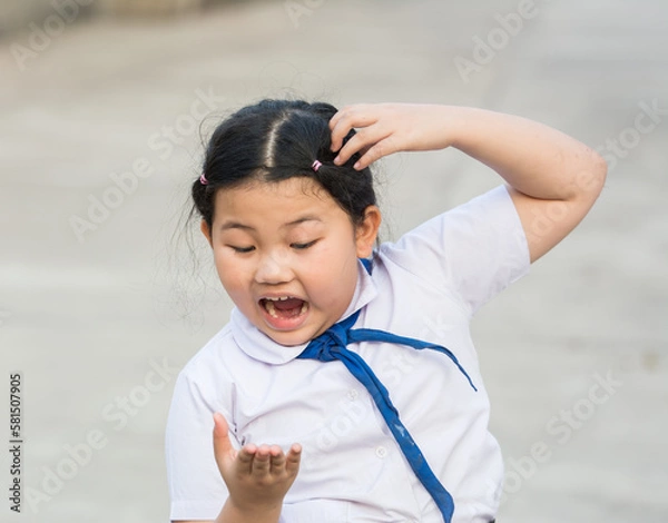 Fototapeta Child student fierce, mad, maniac, maniacal, rabid, wild because lice on the head,she is symptoms itching,scratch head for lice and frightened,agape