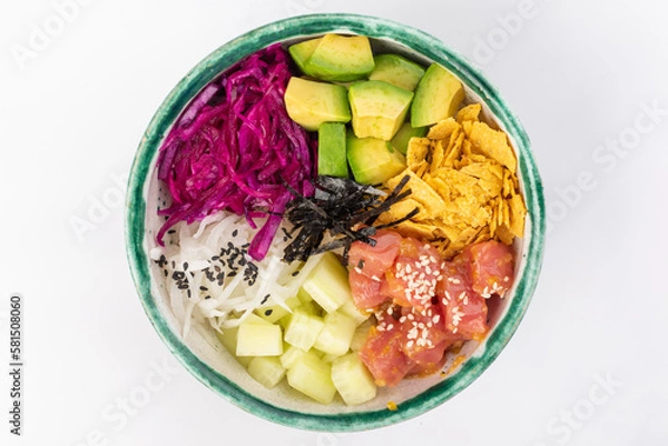 Fototapeta Bowl with tuna, avocado, red cabbage, nachos, cucumber, nori, white and black sesame seeds. Round green bowl on a white background. Top view.