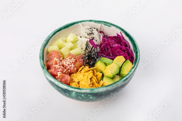 Fototapeta Bowl with tuna, avocado, red cabbage, nachos, cucumber, nori, white and black sesame seeds. Round green bowl on a white background. Close up 3/4