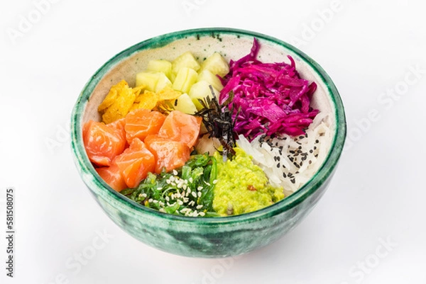 Fototapeta Bowl with salmon, avocado, red cabbage, nachos, cucumber, nori, white and black sesame, chuka. Round green bowl on a white background. Close up 3/4