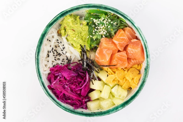 Fototapeta Bowl with salmon, avocado, red cabbage, nachos, cucumber, nori, white and black sesame, chuka. Round green bowl on a white background. Top view.