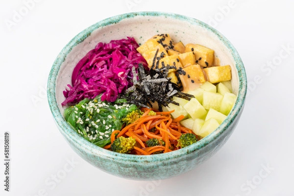 Fototapeta Bowl with tofu, carrots, broccoli, chuka, red cabbage, nori, white and black sesame seeds. Round green bowl on a white background. Close up 3/4