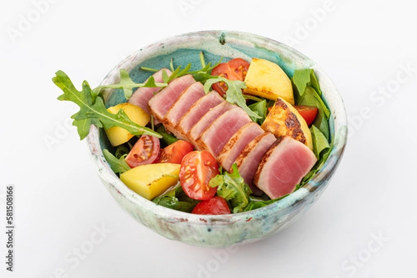 Fototapeta Poke bowl with tuna, cherry tomatoes, arugula, spinach, herbs, fried pineapples and soy sauce. Round bowl on a white background. Close up 3/4/