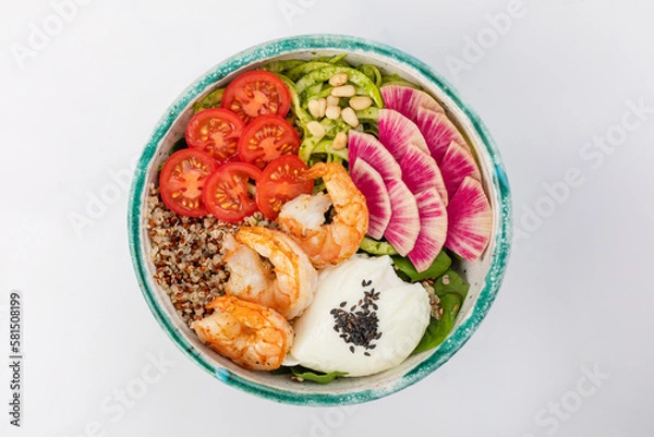 Fototapeta Poke bowl with shrimp, quinoa, poached egg, celery, cherry tomatoes, herbs, pine nuts and sesame seeds. Green round bowl on a white background. Top view.