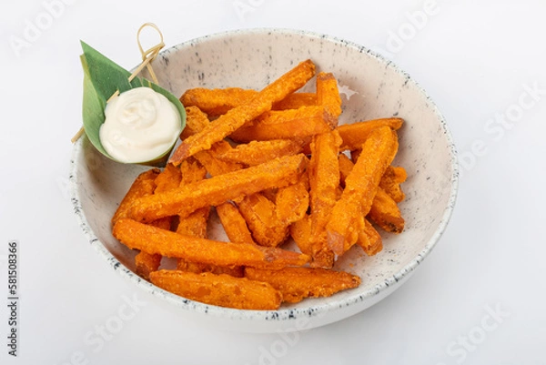 Fototapeta Deep-fried sweet potato slices on a round ceramic plate. White sauce in a banana leaf. Close up 3/4