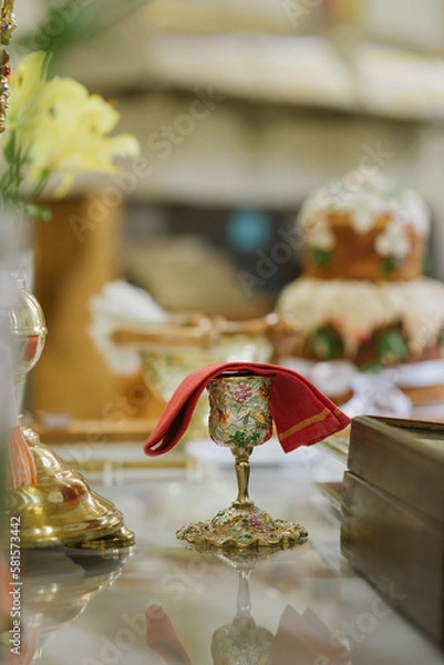 Fototapeta Holy communion in golden cup on table on church.Taking holy Communion.Cup of glass with red wine.