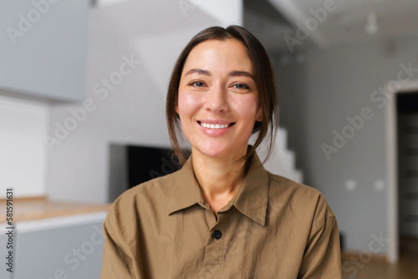 Fototapeta Portrait of happy young woman looking at the camera and smiling. Concept of video call, online communication on the laptop. Webcam view, video chat