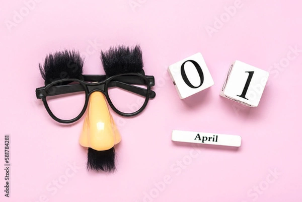 Fototapeta funny face - fake eyeglasses, nose and mustache, calendar with date 01 April on pink background Happy fools day concept 1st April party Holiday greetind card