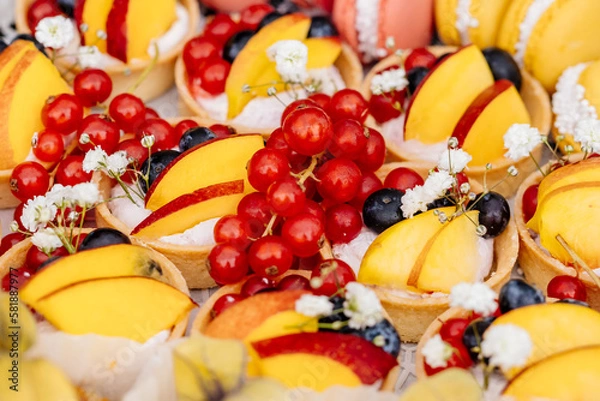 Obraz Johannisbeeren umringt von Pfirsich und Heidelbeeren in Teigschalen mit Quark als Obstplatte beim Buffet einer Gartenparty oder Hochzeitsfeier als gesunder Snack