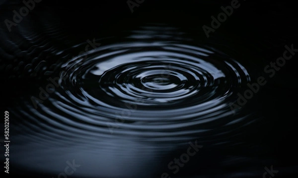 Fototapeta Ripple of water or water drop splash on black background. Abstract shape out of the water