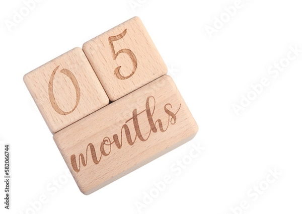 Fototapeta A wooden block showing the date of birth of a newborn child on a white background.