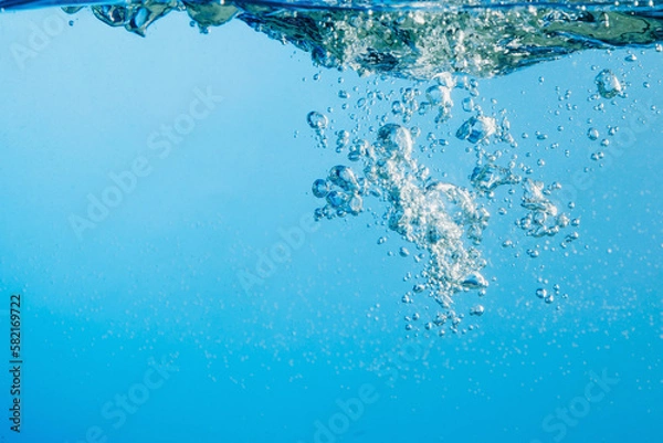 Fototapeta Abstract clear blue water. Splash with bubbles. Copy space
