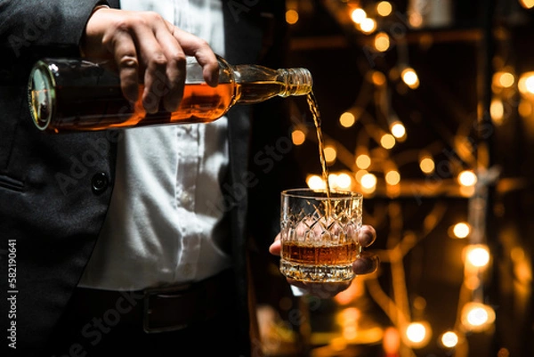 Fototapeta Businessman pouring whiskey victory drink