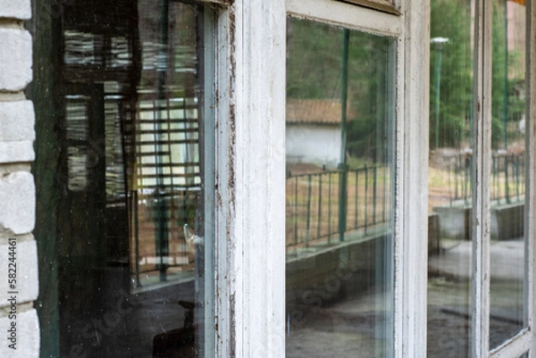 Fototapeta An interesting view of old windows in a forgotten building in the style of the 80's, urbex. day.