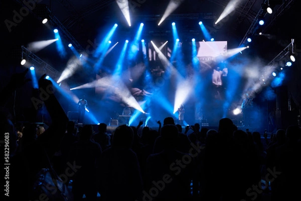 Obraz Colourful concert arena with a crowd silhouette against stage lights. silhouettes of the audience against the background of the concert stage