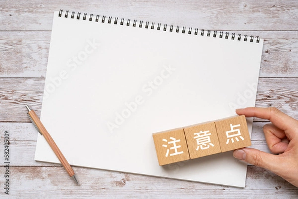 Obraz 注意点と書かれたブロック、ノート、ペン、手