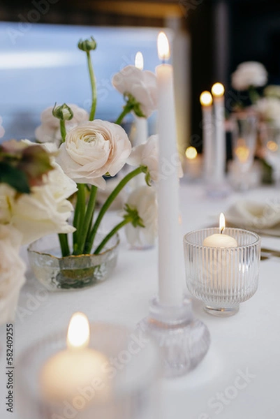 Fototapeta Banquet table decorated with plates, cutlery, candles, glasses and flower arrangements